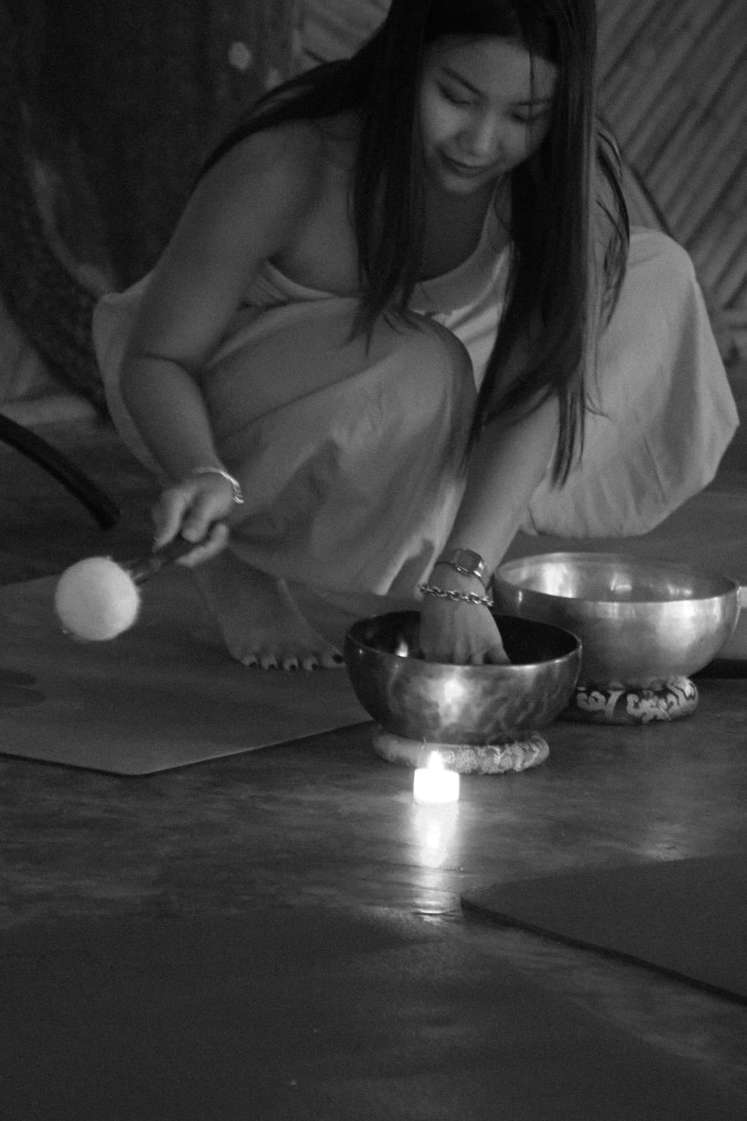 Yok preparing a singing bowl by candlelight